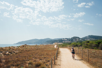 Un cycliste sur un sentier côtier de la Costa Brava. Une balade sur un chemin entouré de dunes de sable.