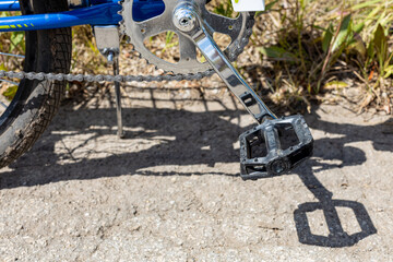 dusty pedal of a bicycle standing on a country road
