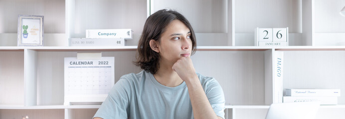 Young Asian men are greeting friends and teachers through video chats and greeting them with cheerful expressions, Online communication , Stay home, VDO Call, Social distancing, Internet learning.