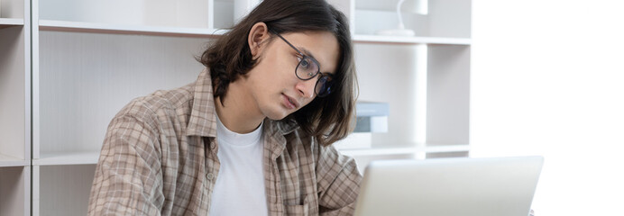 Young studying online uses his laptop in a live performance to communicate with his friends and teachers, Using laptops and data graphs in class, Online communication, Social distancing.