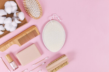 Eco friendly wooden beauty and hygiene products like comb and soap on pink background