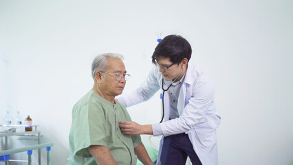 Portrait of Asian doctor check up body or heart by stethoscope of sick old senior elderly patient...