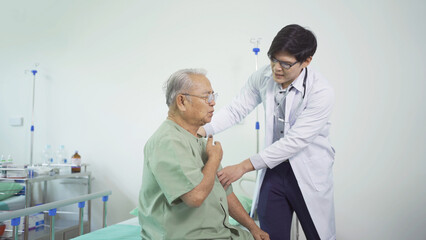 Happy old elderly Asian patient or pensioner and a doctor smiling, doing exercise, working out  in nursing home in hospital. Senior people lifestyle activity recreation. Health care physical therapy.