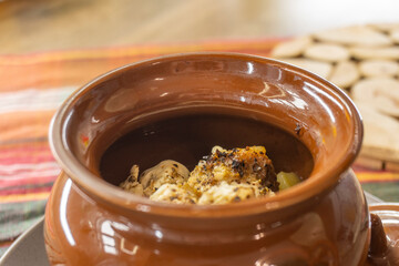 stewed vegetables in a clay pot on a wooden background. food concept.