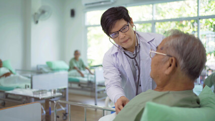 Obraz premium Portrait of Asian doctor check up body or heart by stethoscope of sick old senior elderly patient on bed in hospital in medical and healthcare treatment at nursing home. People lifestyle