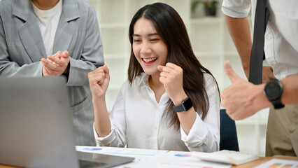 Asian female employee excited with her project result, getting a promotion