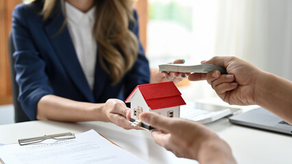 A female real estate agent receives a house loan payment or mortgage fees from her client.
