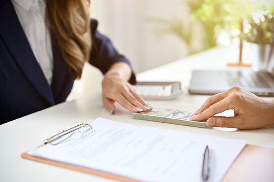 Female real estate agent or realtor receiving a house loan from her client. cropped image
