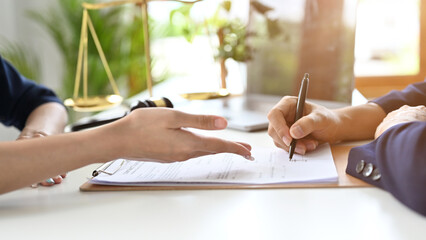 A professional female lawyer meets with her client in private to consult to sign the contract