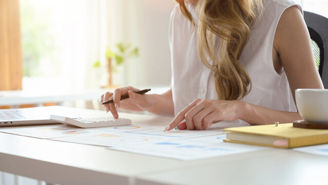 A professional businesswoman working on her accounting sales report. cropped image