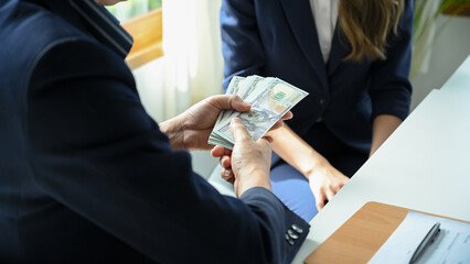 A businessman tries to give money or bribe to a female worker or lawyer. Corruption