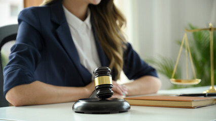 A professional female lawyer or business legal consultant sits at her office desk.