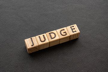 Judge - word from wooden blocks with letters, Judge, try, referee, adjudicate concept, black...