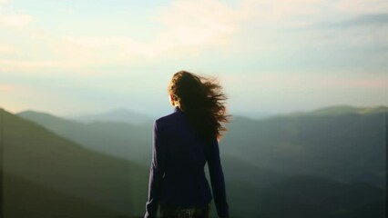 Young girl running up on top of mountains at sunset, raises arms into air. Concept of freedom and success. 