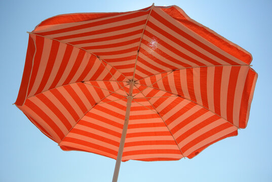 Orange gestreifter Vintage Sonnenschirm von unten mit Blick in den Himmel, Sonnenschutz, Urlaub im S&uuml;den