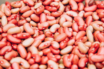 Closed background of many beans of pink-red color. Bean texture, selective focus