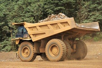 A haul truck is transporting material at a nickel mine site. Rigid dump trucks specifically...