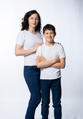 woman with a boy. Mom with son on a white background. family portrait in white t-shirts and blue jeans