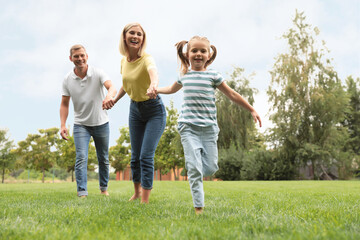 Fototapeta premium Happy family running in park on summer day