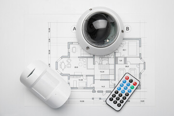 CCTV camera, remote control, movement detector and building plan on white background, flat lay. Home security system