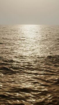 The light of the setting sun is reflected in the sea ripples