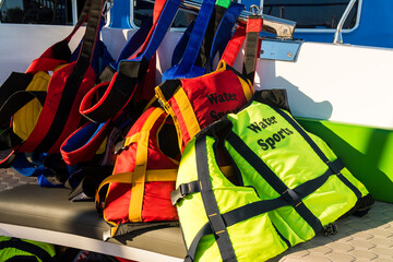 Coloful life vests ready in boat before water sports excursion