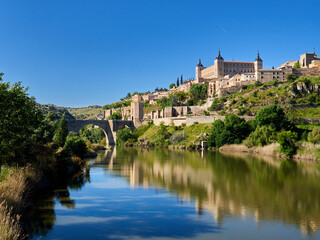 Panoramic view of Toledo with Alcantara bridge over Tagus river, the city wall and the Alcazar....