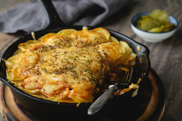 Potato casserole with meat and cheese in a frying pan