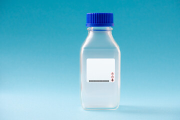 chemical gas in glass bottle on blue background with danger symbol