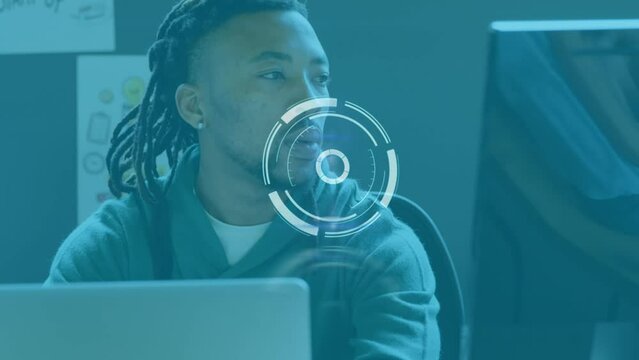 Animation of scanning icon moving over african american businessman with dreadlocks using laptop