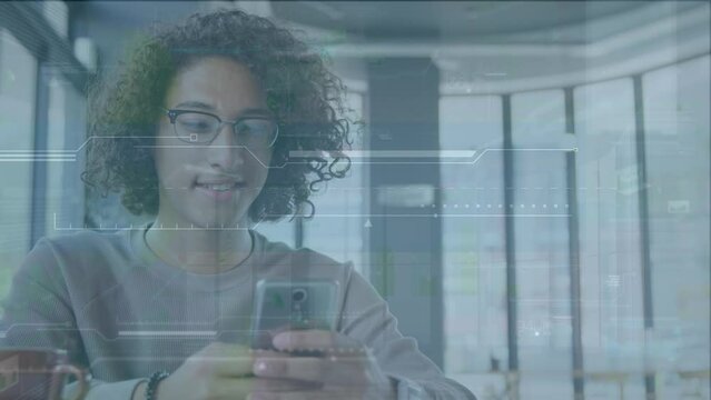 Animation of digital interface over smiling biracial young man with curly hair using mobile phone