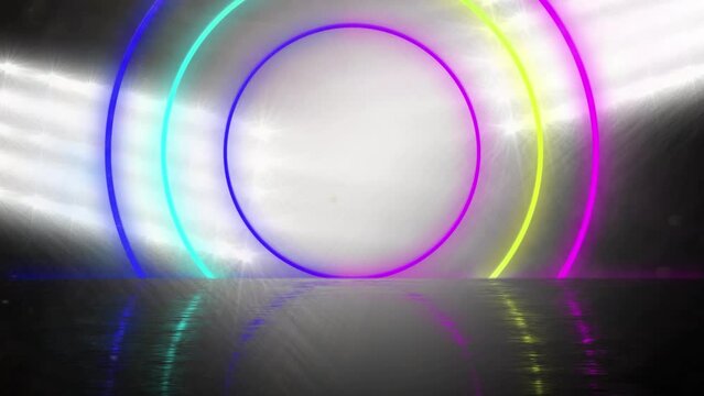 3d animation of colorful circular neon beams zooming against glowing flood light at stadium