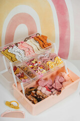 Organizer with fashion hair bows, hairpins and hair elastics on white table in Children's room. Nursery Organizing and Storage Ideas. Baby Girl hair accessory. Hairstyles for girls with bows.