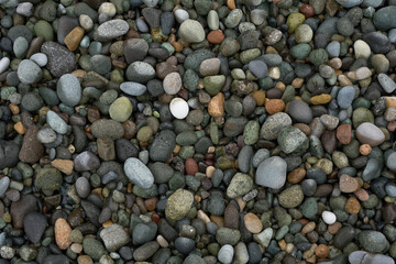 Pebble beach stones background, natural rounded gravel on the seashore nature background texture pattern
