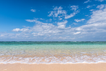 Fototapeta na wymiar Gentle turquoise sea wave on clean sand beach. Selective focus.