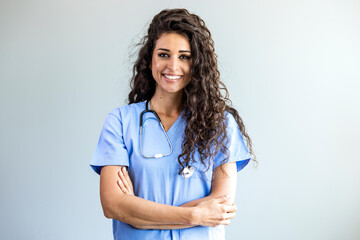 Smiling female healthcare professional looks at the camera while in hospital hallway. She is...