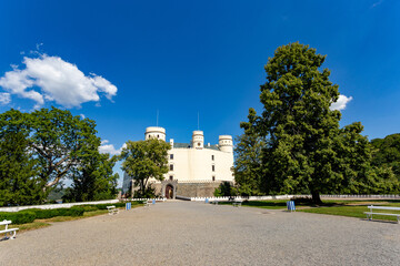 Obraz premium Orlik castle with blue sky and trees. Orlik nad Vltavou, Czechia