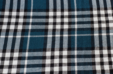 Checkered fabric background in white, black and blue colors.