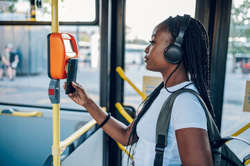 African american woman paying a bus ticket via smartphone during a ride