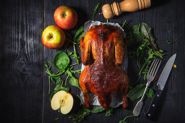  Baked duck with apples on a black wooden table