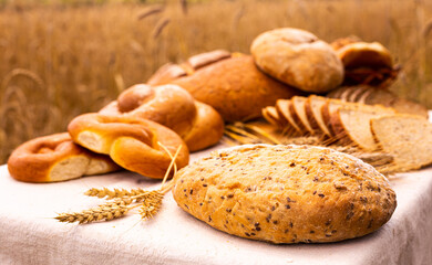 lot of different flavored bread, wheat, rye, on the table in the field outside