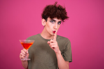 Drag queen drinks a cocktail. Funny guy in make-up.	