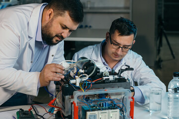Two scientists are working on the development of a new device