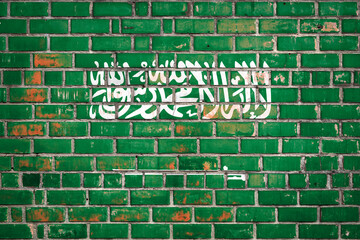 National  flag of the Saudi Arabia on a grunge brick background.