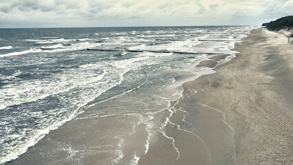Unquiet Baltic Sea after a storm. Polish Baltic shore near Dziwnow and Trzesacz towns. Empty beach...