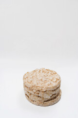 Exquisite round rice crackers on a white surface. Copy Space. Healthy eating.