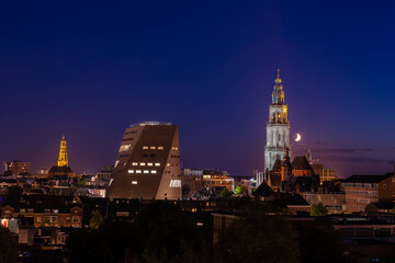 Fototapeta na wymiar Overview of cityscape with architecture features traditional houses and church at night, A city in the northern of Netherlands, The capital city and main municipality of Groningen province in Holland.