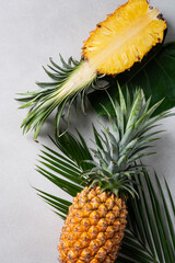 Fresh cut pineapple with tropical leaves on dark blue background.