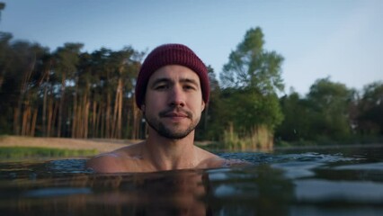 Portrait view of the bearded man feeling cold and chills while having winter swimming at the cold lake at the forest