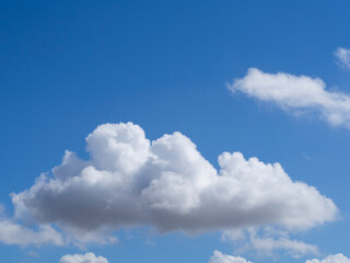 Naklejka na ściany i meble Clouds on a clear blue sky background. A cloud on a blue sky background